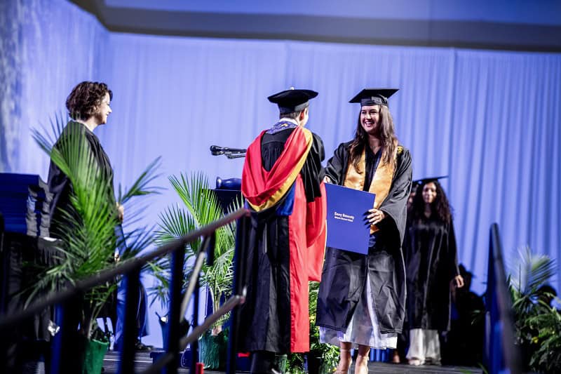 Dean James hands out diplomas during Goizueta Commencement 2024.